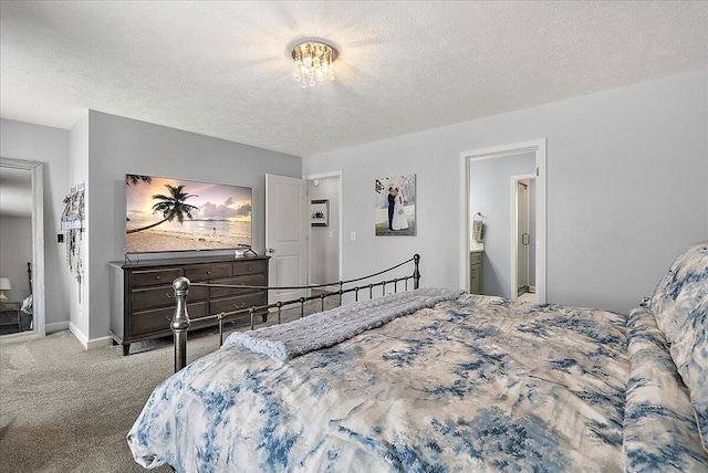 bedroom featuring ensuite bathroom, a textured ceiling, and carpet flooring