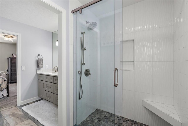 bathroom featuring walk in shower, vanity, and a textured ceiling