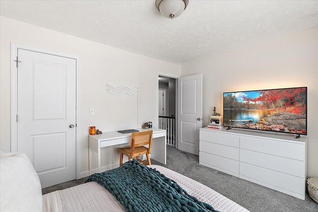 bedroom with dark carpet and a textured ceiling