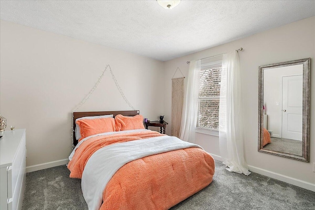 bedroom featuring dark carpet and a textured ceiling