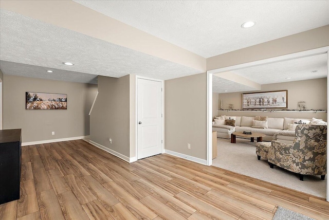 living room featuring a textured ceiling and light wood-type flooring