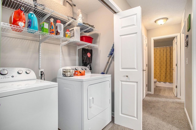 washroom with separate washer and dryer, light colored carpet, and a textured ceiling