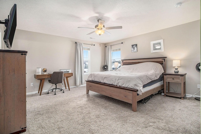 carpeted bedroom with ceiling fan and a textured ceiling