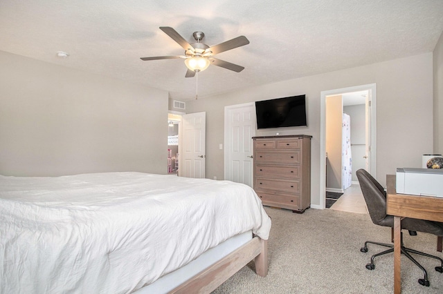 carpeted bedroom with a textured ceiling, ceiling fan, and connected bathroom