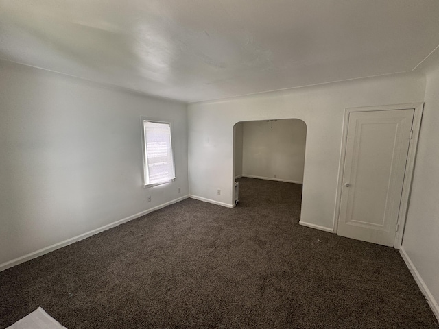 empty room with dark colored carpet