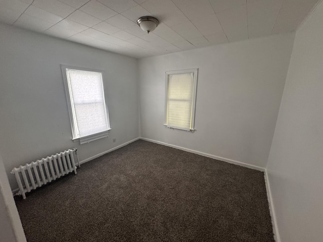 carpeted empty room with radiator heating unit