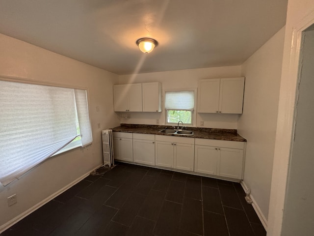 kitchen featuring a wealth of natural light, white cabinets, and sink