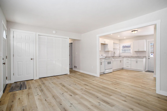 kitchen with sink, white electric stove, white cabinets, and light wood-type flooring