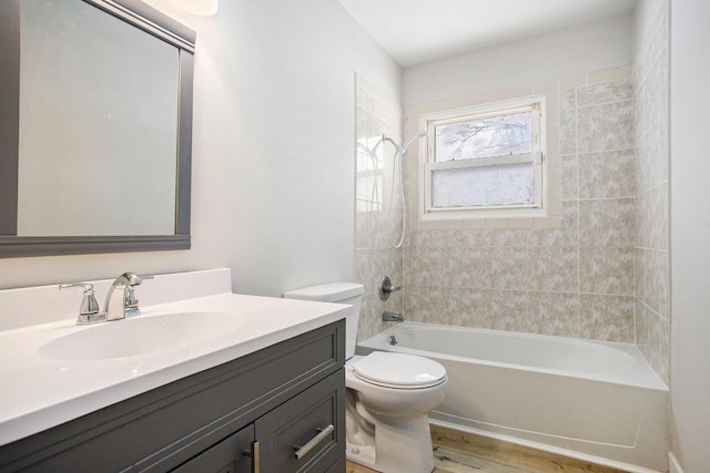 full bathroom with wood-type flooring, toilet, vanity, and tiled shower / bath