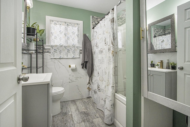 full bathroom featuring toilet, vanity, tile walls, and shower / bath combo with shower curtain