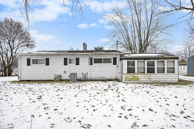 snow covered rear of property with central air condition unit