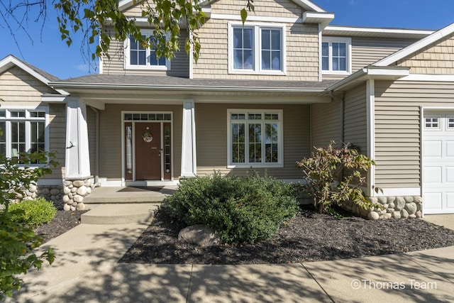 property entrance featuring covered porch and a garage