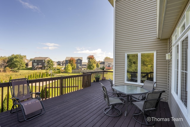 wooden terrace featuring a lawn