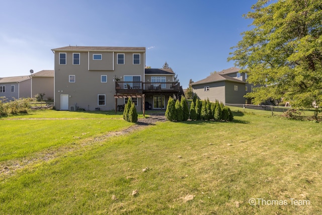 back of property featuring a deck and a yard