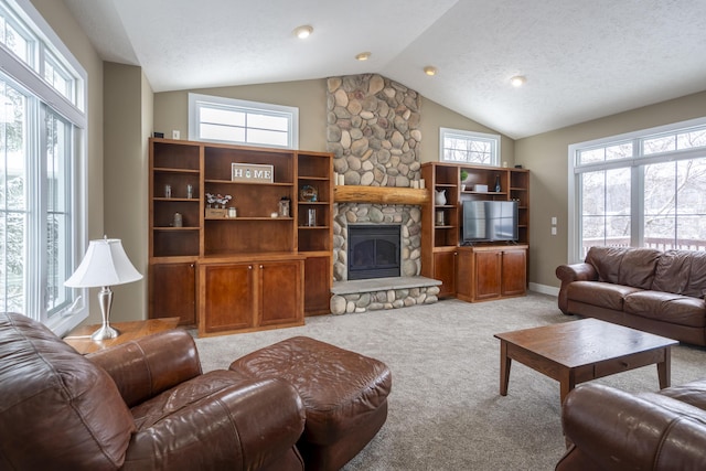 carpeted living room featuring vaulted ceiling, a textured ceiling, a healthy amount of sunlight, and a fireplace