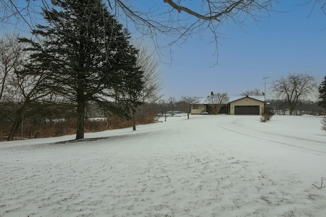 snowy yard featuring a garage