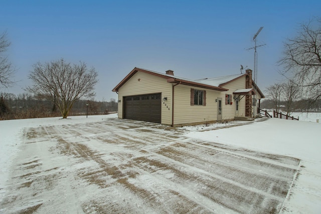 snow covered property with a garage