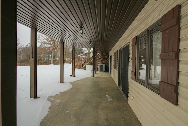 snow covered patio with cooling unit