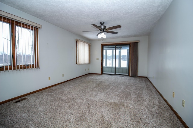 carpeted empty room with a textured ceiling and ceiling fan