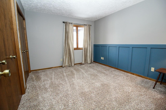 empty room featuring light carpet and a textured ceiling