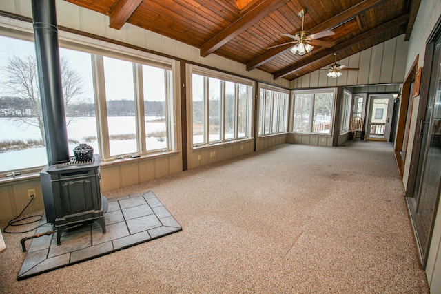 sunroom / solarium featuring wood ceiling, a wood stove, a water view, vaulted ceiling with beams, and a healthy amount of sunlight