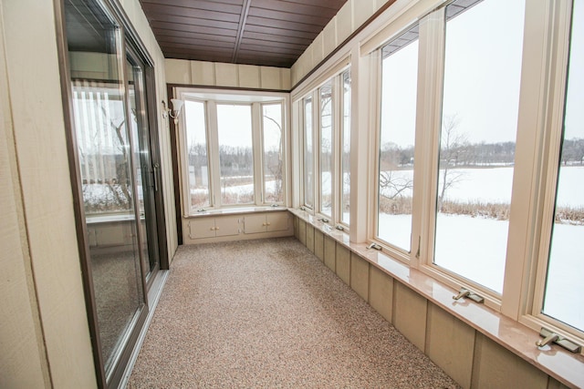 unfurnished sunroom featuring wooden ceiling and a water view