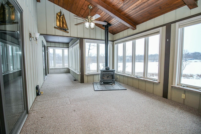 unfurnished sunroom with wooden ceiling, a wood stove, a water view, vaulted ceiling with beams, and ceiling fan