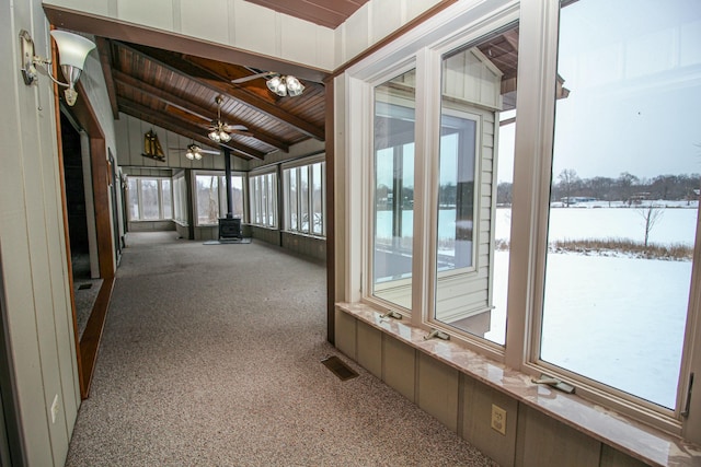 corridor with wooden ceiling, vaulted ceiling with beams, and carpet floors