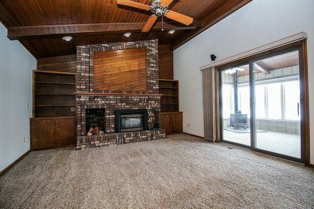 unfurnished living room with wood ceiling, a brick fireplace, carpet flooring, and beamed ceiling