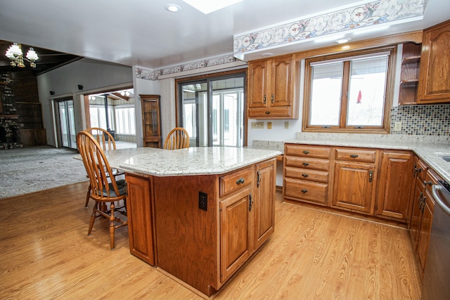 kitchen with dishwasher, light hardwood / wood-style flooring, plenty of natural light, and a kitchen island