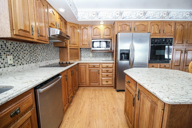 kitchen featuring light stone counters, black appliances, tasteful backsplash, and light hardwood / wood-style flooring