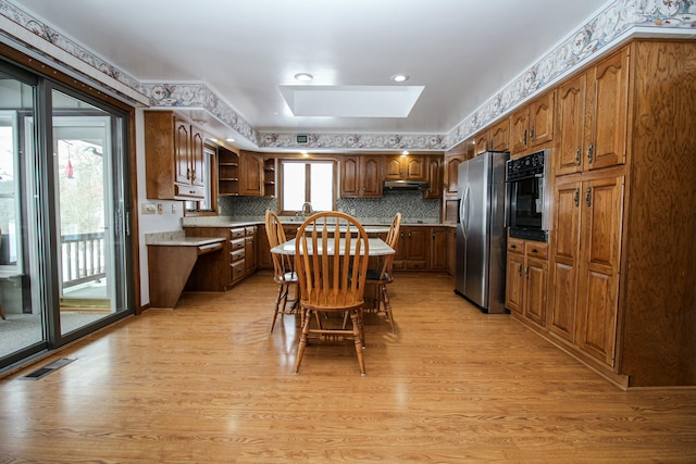 kitchen with stainless steel fridge with ice dispenser, a healthy amount of sunlight, and light hardwood / wood-style floors