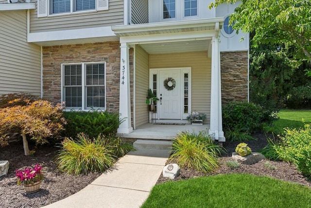 property entrance with stone siding and a porch