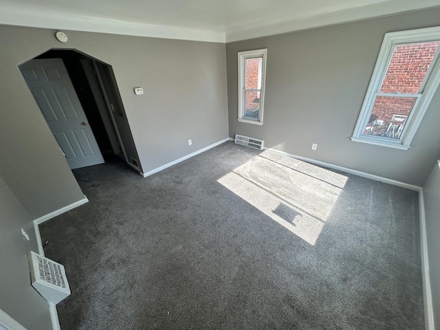 spare room featuring dark colored carpet