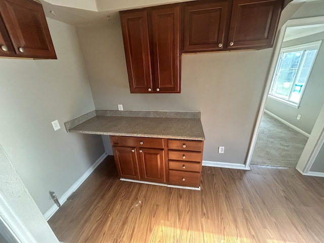 kitchen featuring built in desk and light hardwood / wood-style flooring