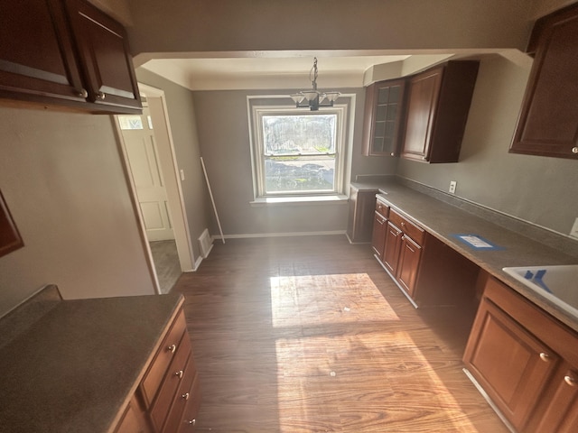 kitchen featuring decorative light fixtures, sink, built in desk, and light wood-type flooring