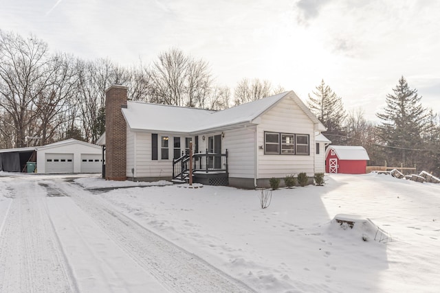 view of front of home with a garage and a storage shed