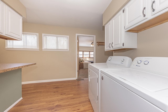 clothes washing area featuring ceiling fan, light hardwood / wood-style flooring, separate washer and dryer, and cabinets