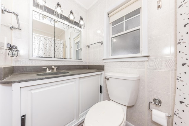 bathroom with toilet, vanity, tile walls, and walk in shower