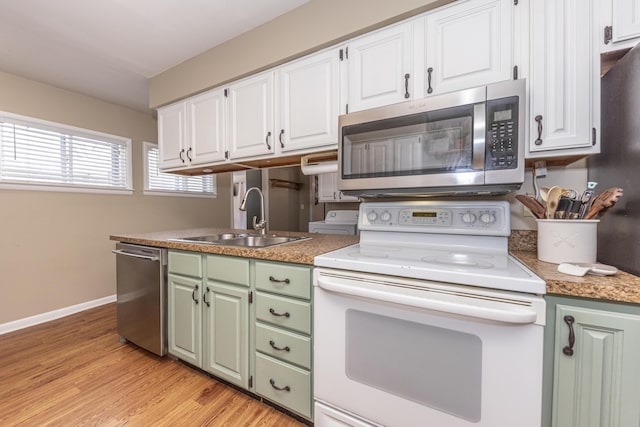 kitchen with sink, white cabinetry, stainless steel appliances, and light wood-type flooring