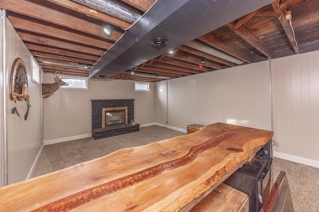 basement with a brick fireplace and carpet flooring