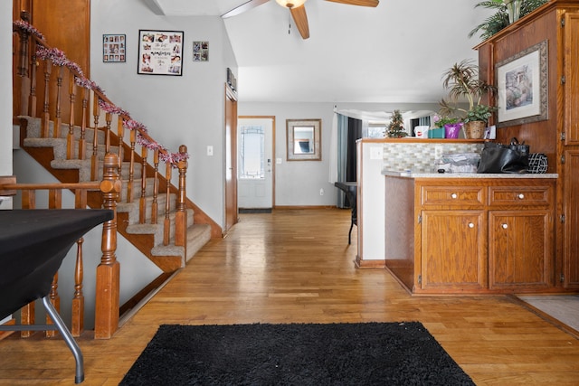 interior space featuring tasteful backsplash, vaulted ceiling, ceiling fan, and light hardwood / wood-style floors