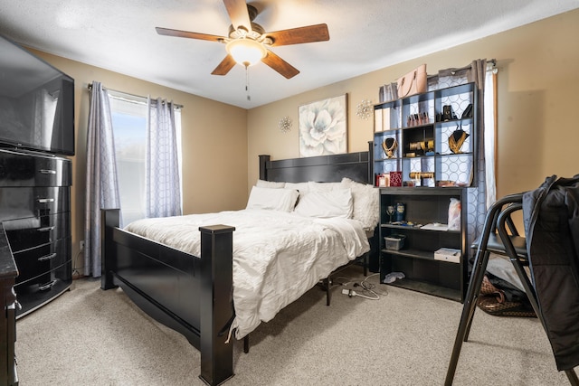 carpeted bedroom with ceiling fan and a textured ceiling