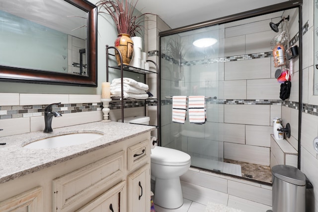 bathroom with vanity, toilet, an enclosed shower, and backsplash