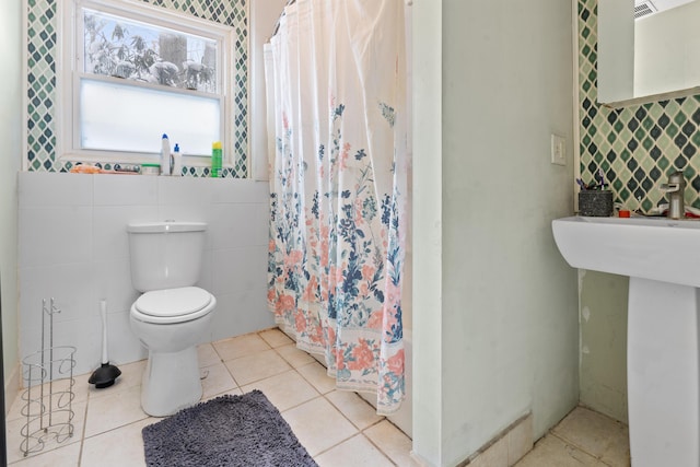 bathroom featuring tile walls, tile patterned floors, toilet, and walk in shower