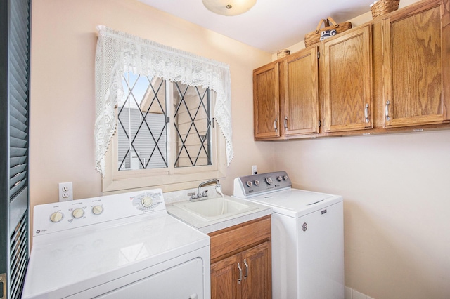 washroom with cabinets, separate washer and dryer, and sink