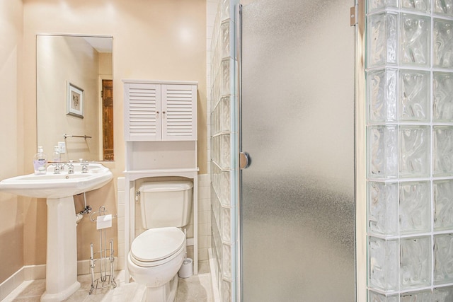 bathroom featuring walk in shower, sink, tile patterned floors, and toilet