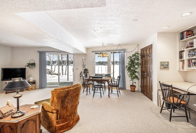 dining space with a textured ceiling, a chandelier, and light colored carpet