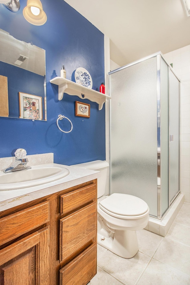 bathroom with toilet, tile patterned floors, a shower with shower door, and vanity