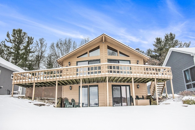 snow covered house with a wooden deck